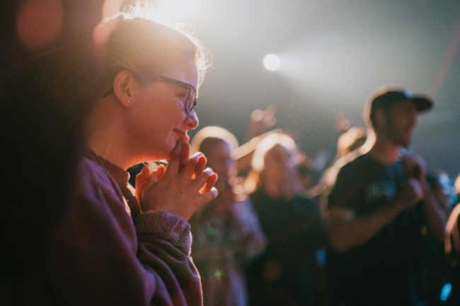Young female, hands clasped below their chin deep in contemplation